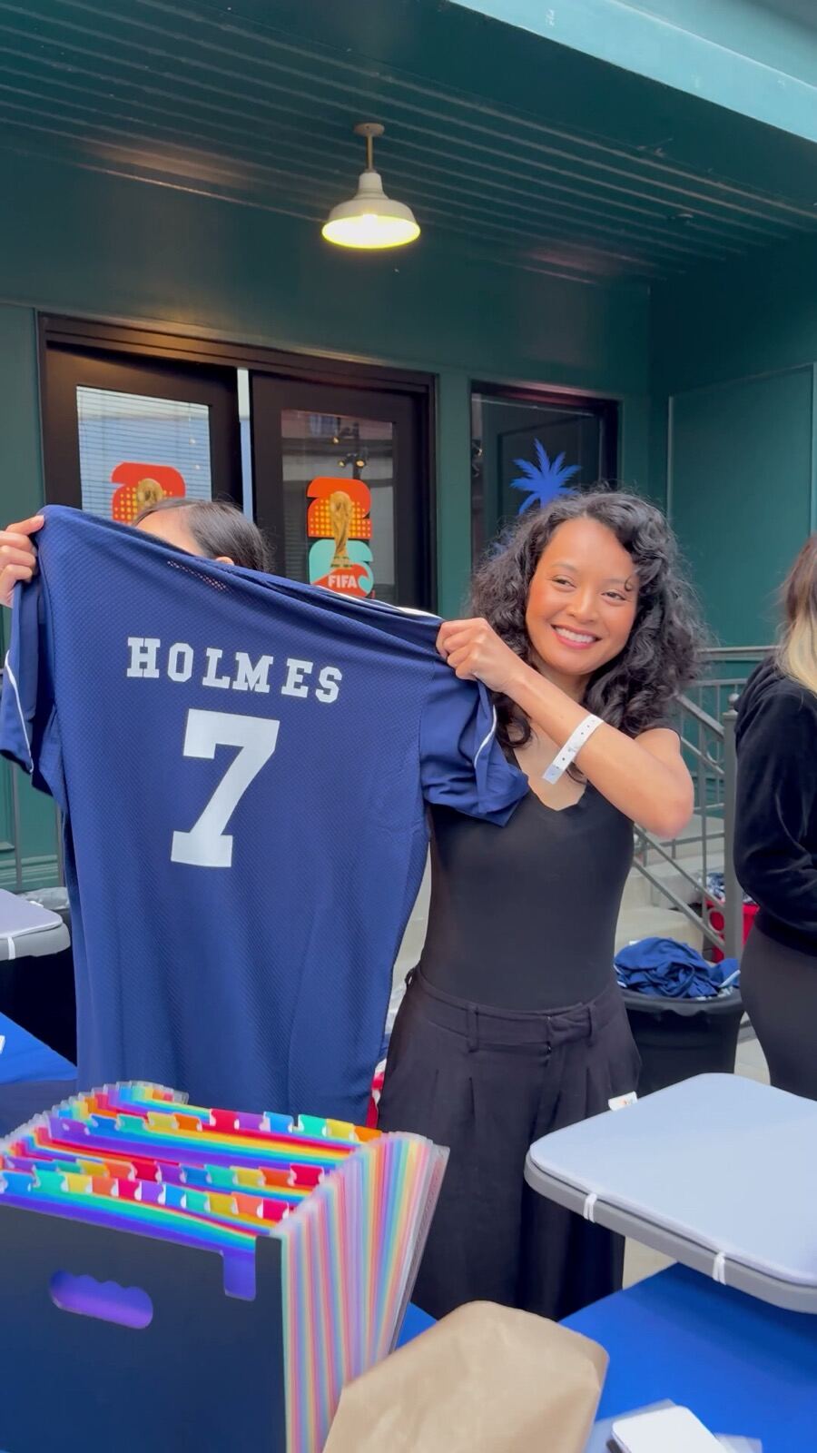 Smiling guest showing off a personalized jersey at an outdoor evening event