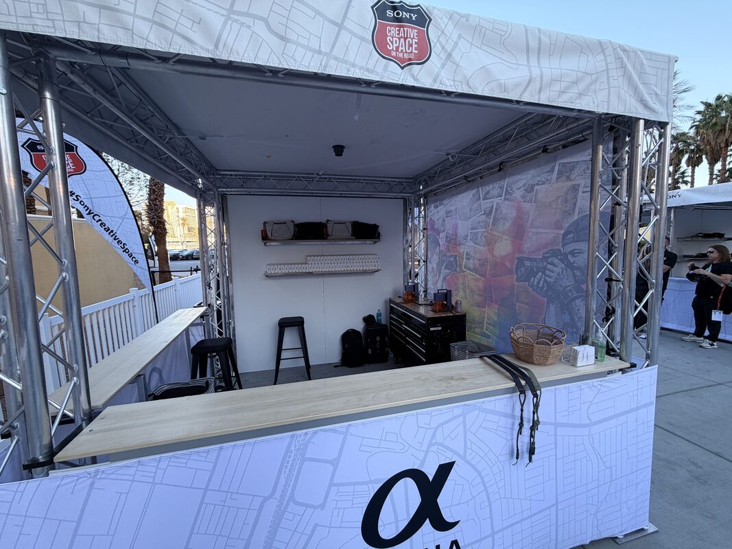 Truss festival booth with plywood counters being set up outdoors before an event opens